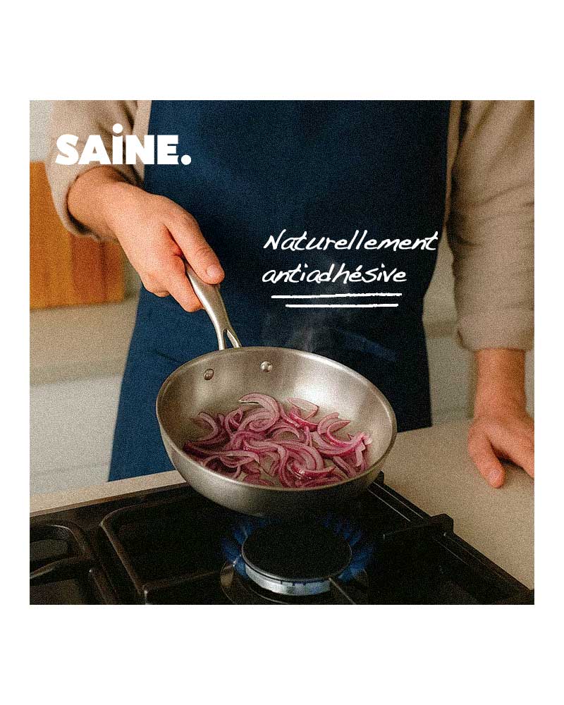 un homme cuit des oignons rouges dans une poele inox antiadhésive