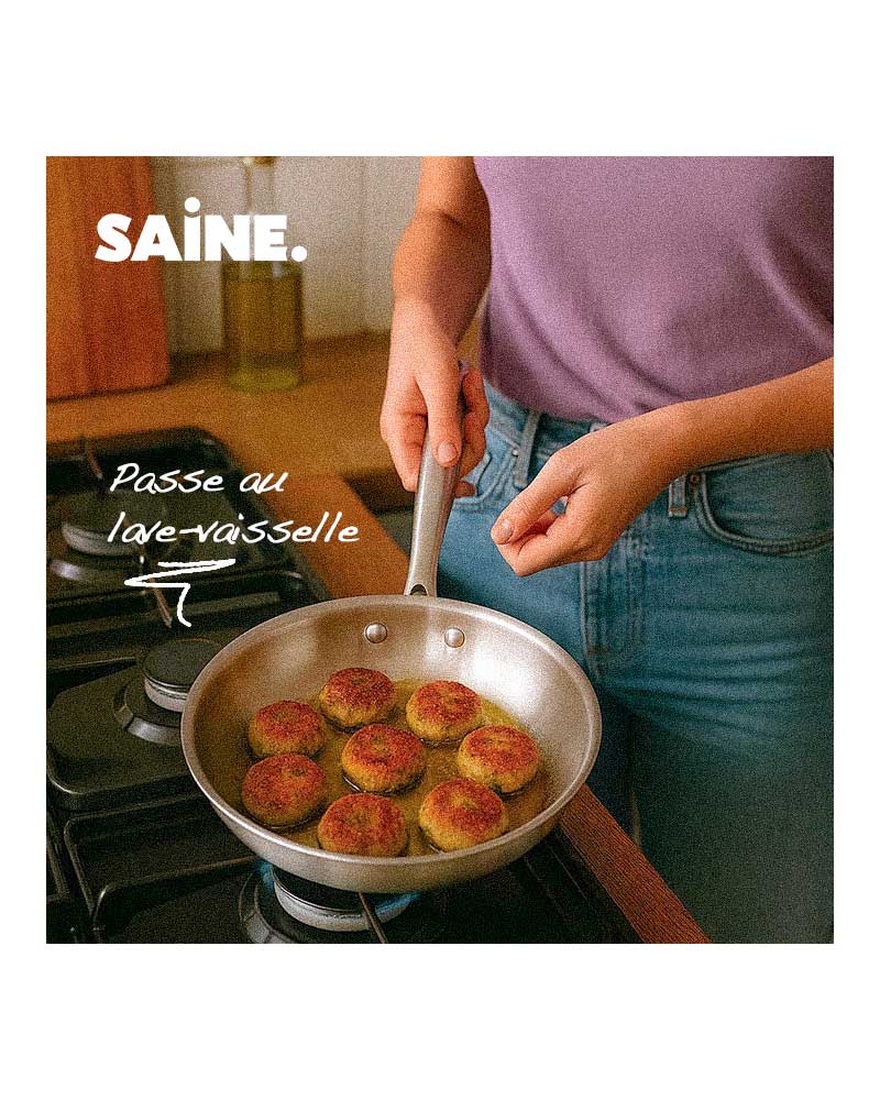 une femme fait la cuisine dans une poêle inox qui passe au lave-vaisselle