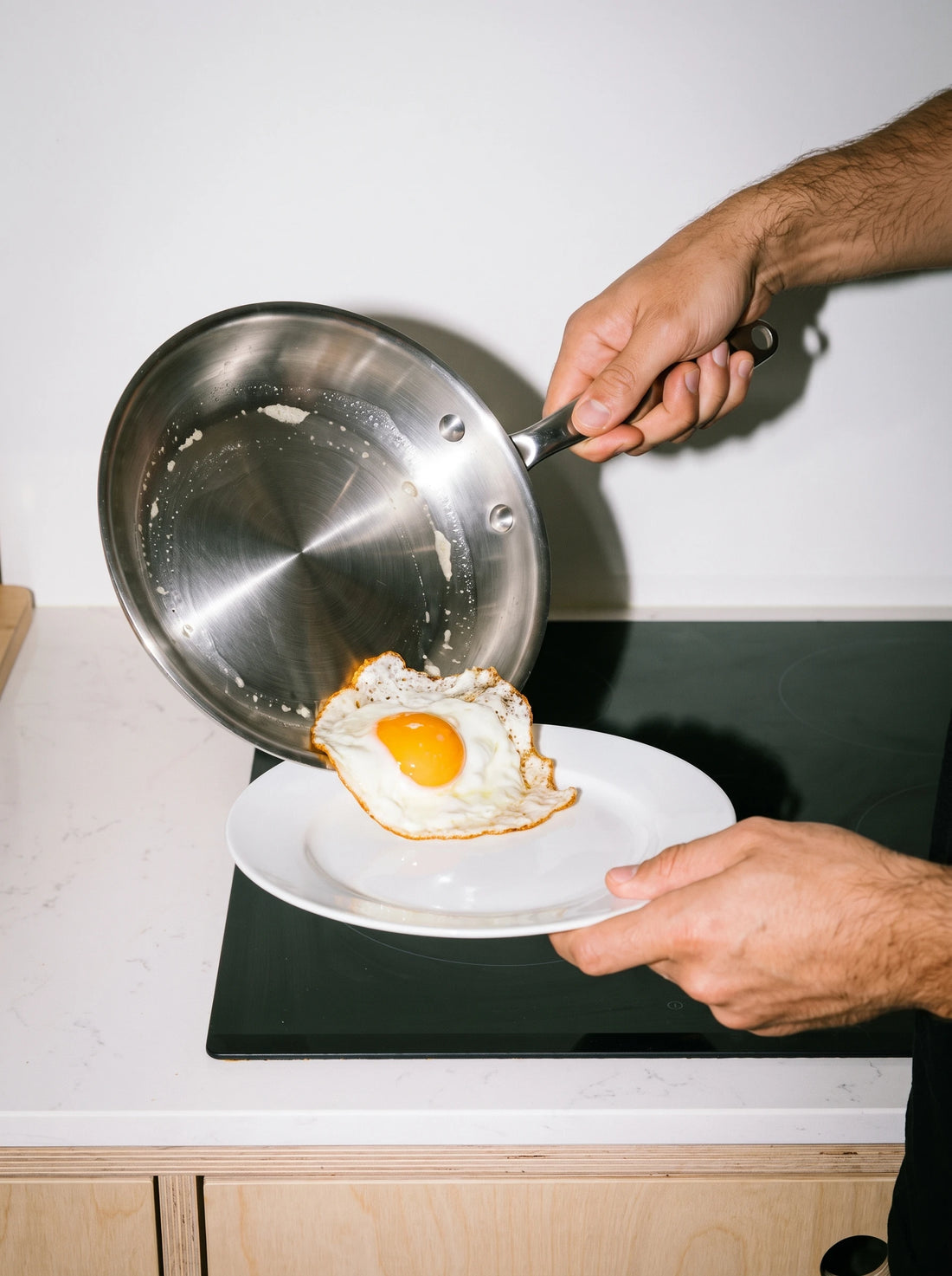 Œuf au plat glissé dans l'assiette depuis une poêle en inox 20 cm SAINE