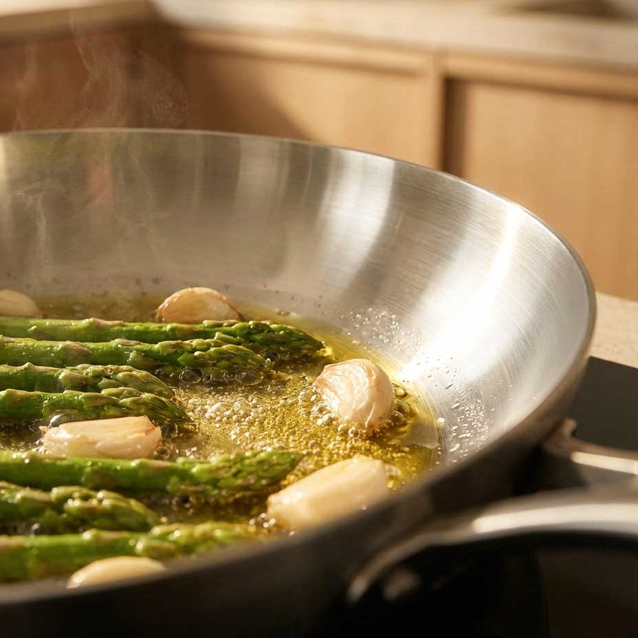 gros plan sur l cuisson d'asperges et d'ail dans une casserole inox
