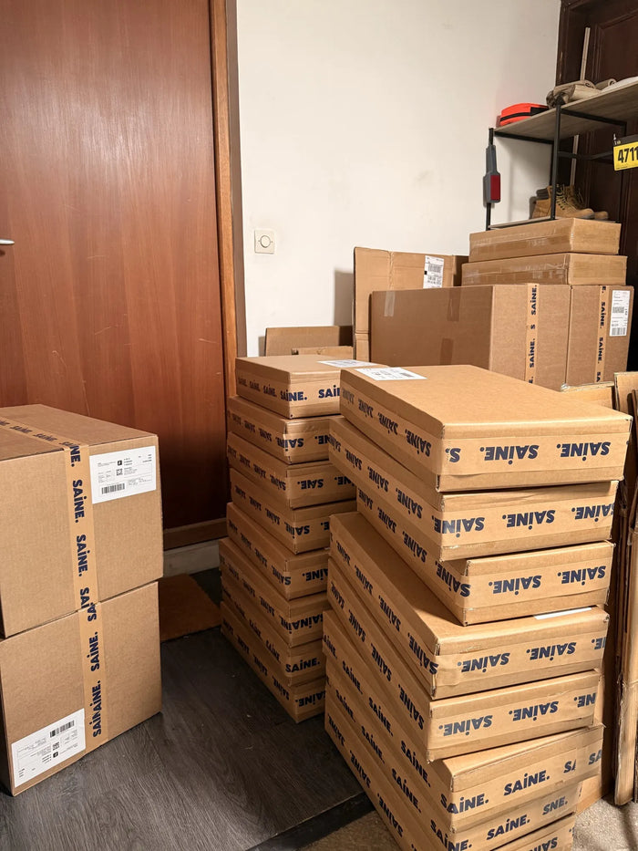 Premiers cartons SAINE de poêles inox empilés dans l'entrée de la maison