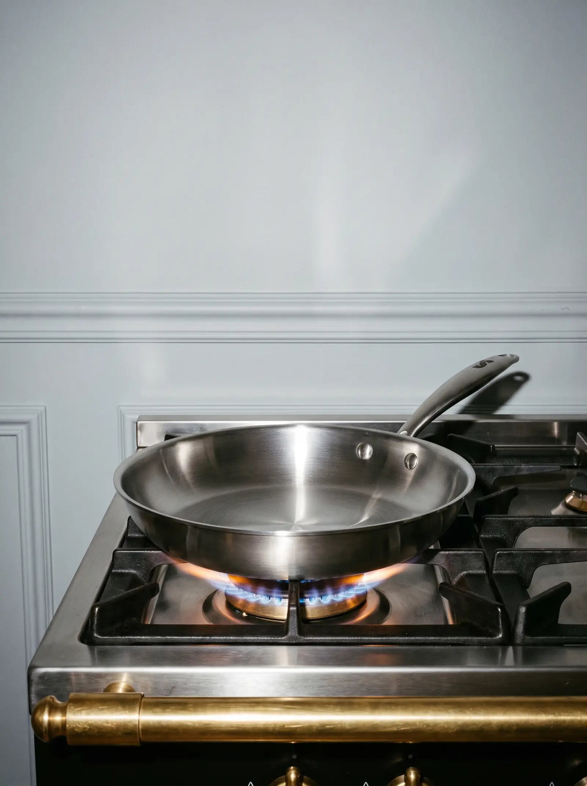 Poêle inox 28 cm SAINE en préchauffage sur le feu d'une cuisinière gaz