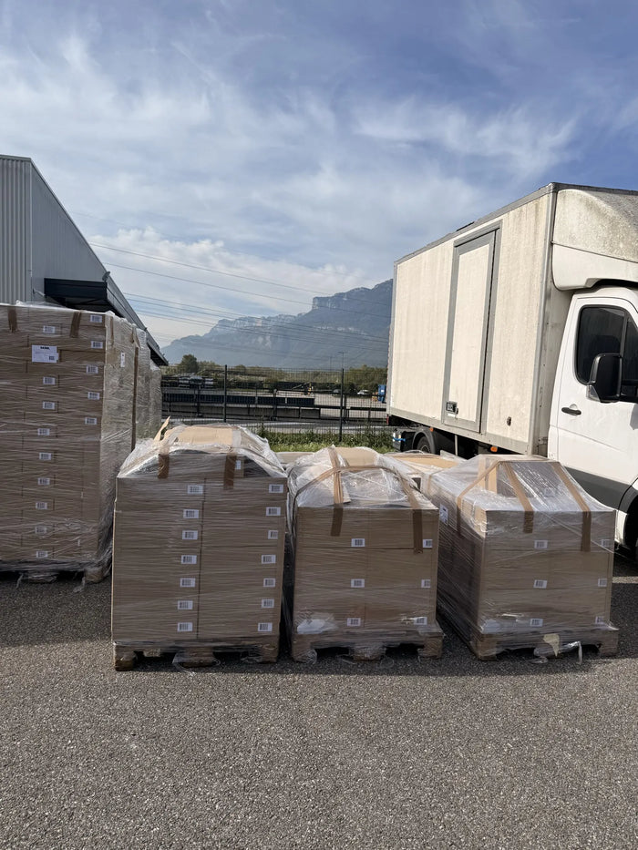 Palettes filmées de cartons SAINE déchargées devant l'entrepôt logistique